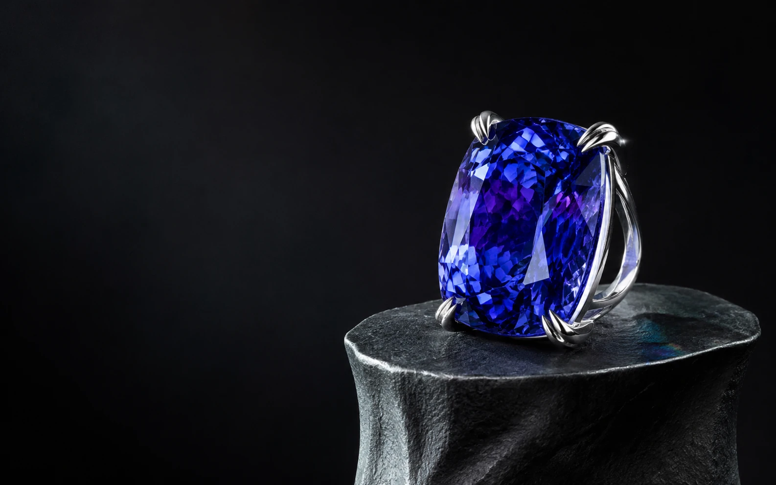 Original CLICO blue-violet ring concept on a dark sculptural pedestal